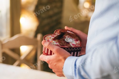 Preview: Man's hands holding Valentine gift, close-up