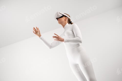Preview: Woman in white suit experiencing virtual reality with VR headset in minimalistic environment