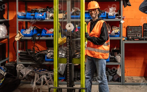 Preview: Smiling Young Mechanic Operating Forklift in Workshop