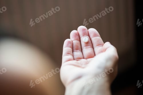 Preview: Close-up of hand holding pill