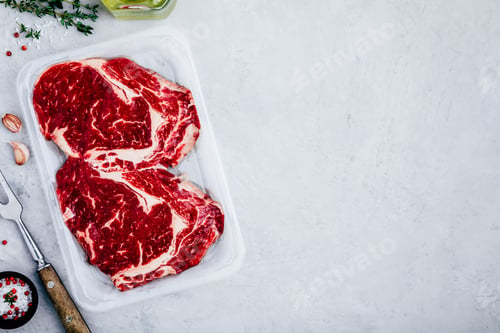 Preview: Ground Beef steak in vacuum packaging with seasonings on gray stone background