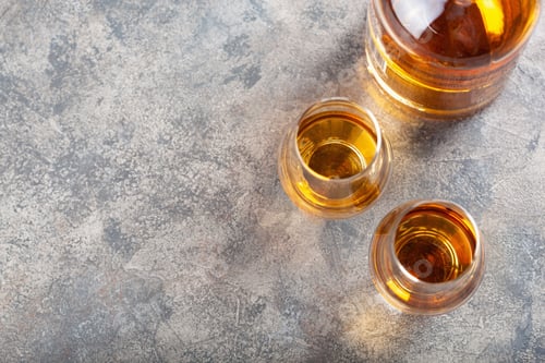 Preview: glass and bottle of whisky spirit brandy on gray concrete background