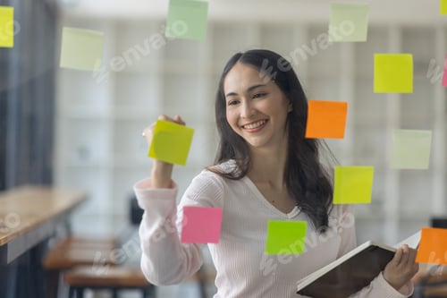Preview: Business female employee with many conflicting priorities arranging sticky notes commenting and brai