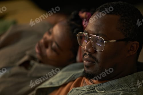 Preview: Black Man Relaxing with Young Black Woman Indoors