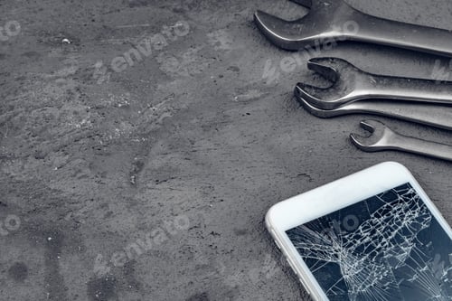 Preview: Crashed smartphone with repairing tools on grey background