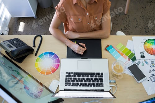 Preview: Female executive working over graphic tablet at her desk