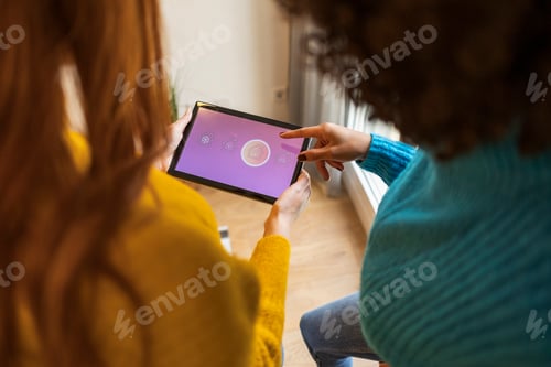 Preview: woman using digital tablet to adjust temperature