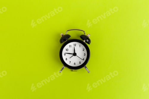 Preview: Vintage black alarm clock on a bright green background