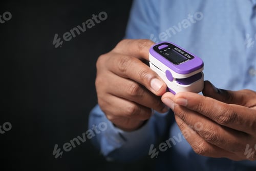 Preview: Close up of patient using pulse oximeter isolated in black