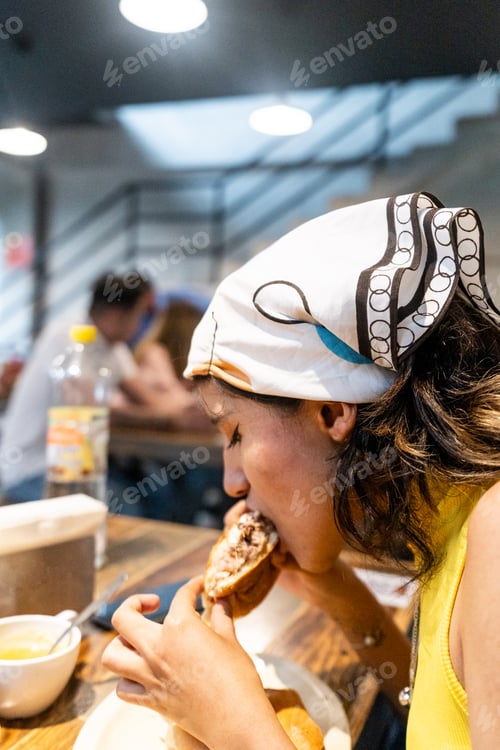 Preview: a young mexican woman eating pork leg torta