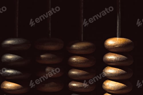 Preview: Wooden beads hang in shadows capturing light and texture in a quiet space
