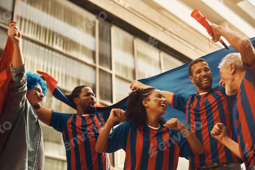 Preview: Group of happy soccer fans having fun while celebrating on the street during the world cup.