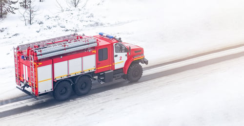 Preview: A red fire truck or Fire engine drives down a snowy street in winter
