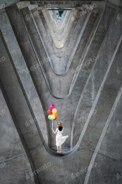 Preview: Portrait of woman holding colorful balloons at structure of cement concrete beams
