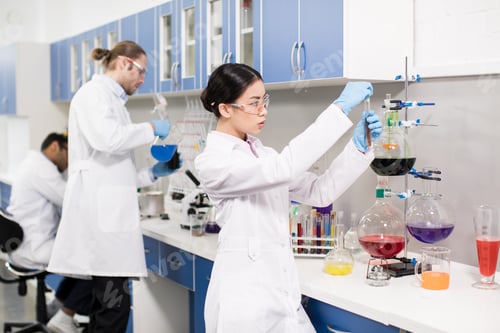 Preview: Group of young professional scientists making experiment in research laboratory