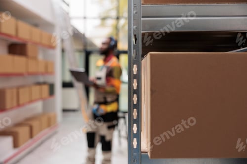 Preview: Selective focus of metallic shelves full with cardboard boxes