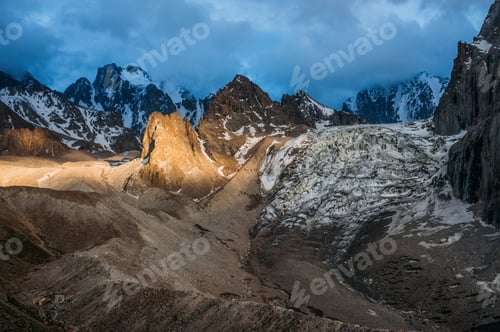 Preview: view of rocky peaks with snow under stormy clouds and partial sun light on terrain, Ala Archa