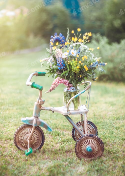 Preview: Retro bicycle in the garden with a bouquet of summer wildflowers