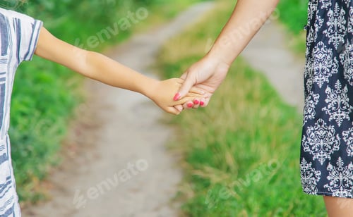 Preview: child goes hand in hand with his mother. Selective focus.