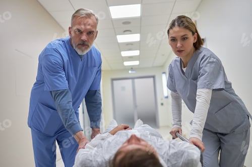 Preview: Middle Aged Male Doctor and Young Adult Female Nurse Transporting Patient