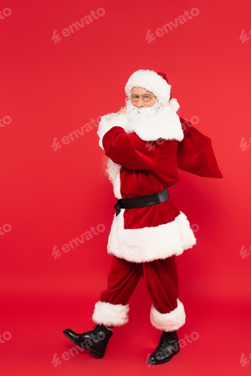 Preview: Santa claus with sack walking on red background