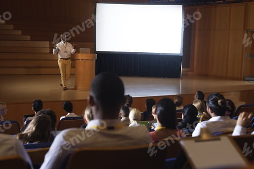 Preview: High view of matured African-American businessman standing and giving presentation in auditorium