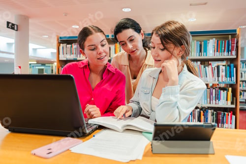 Preview: Three young women studying together in a university library, collaborating on assignments and