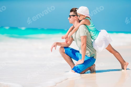 Preview: Little girl and happy dad having fun during beach vacation