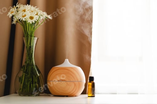 Preview: Aromatherapy concept. Aroma oil diffuser on the table against the window.