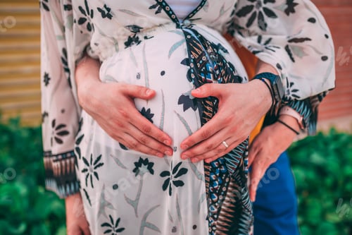 Preview: Husband hugging a pregnant woman outdoors