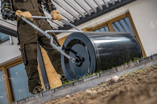 Preview: Professional Landscaper Pushing Large Grass Roller To Flatten Newly Installed Natural Grass Turfs.