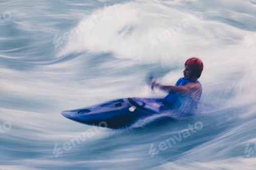 Preview: Long exposure of male whitewater kayaker paddling and surfing large rapids on a fast flowing river.