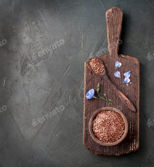 Preview: Flax seed in wooden plate and flax blue flower