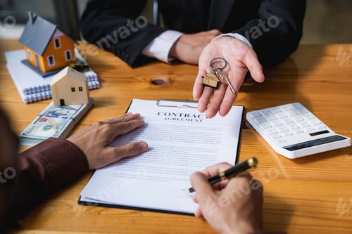 Preview: Real estate agent giving key from new house to young man in office