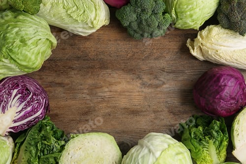 Preview: Frame of different cabbages on wooden background, flat lay. Space for text