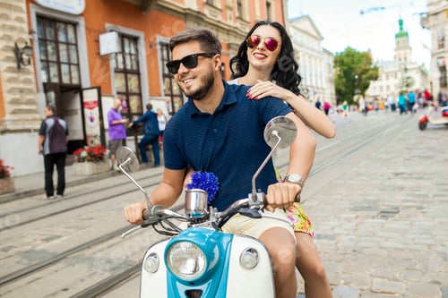 Preview: young beautiful hipster couple riding on motorbike city street