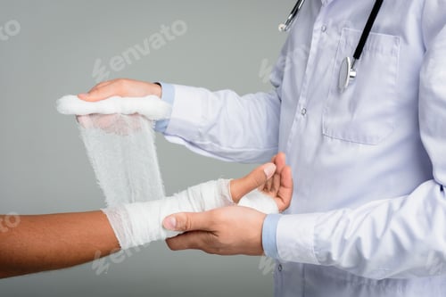 Preview: cropped view of doctor puting bandage on womans hand, isolated on white