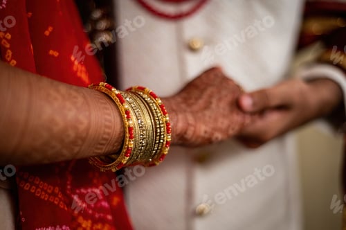 Preview: Closeup of Indian marriage couple hands with henna and jewelry