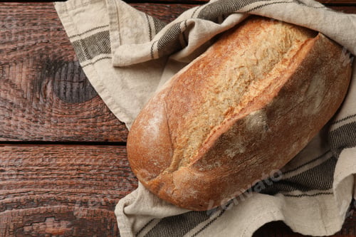Preview: Fresh loaf of bread on wooden table, top view. Space for text