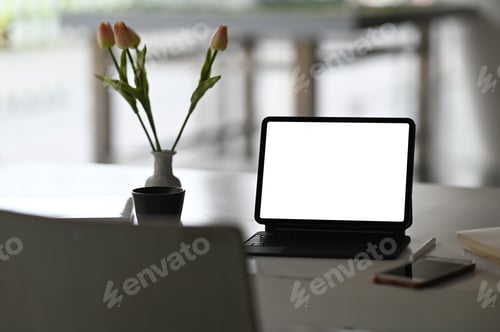 Preview: A computer tablet with a white blank screen is putting on a working desk.