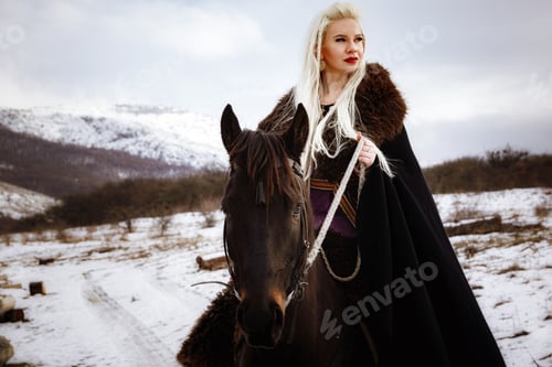 Preview: Woman viking with a black horse against the background of mountains