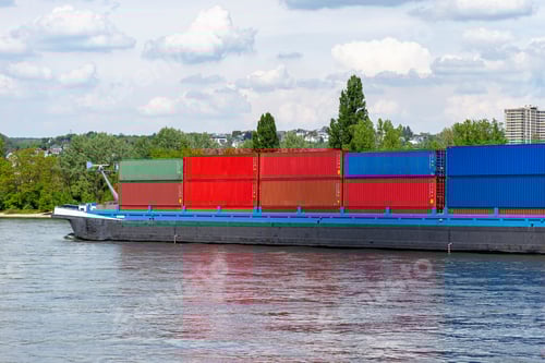 Preview: A barge carrying many containers on the Rhine in western Germany, trees and buildings in background