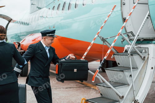 Preview: Aircraft crew in work uniform is together outdoors near plane