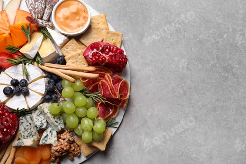 Preview: Assorted appetizers served on light grey table, top view. Space for text