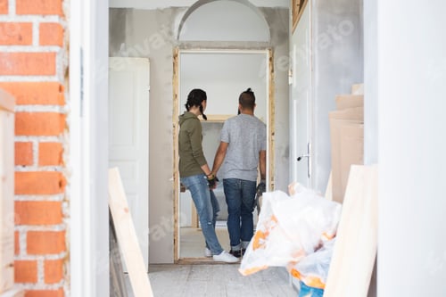 Preview: Couple standing in doorway and looking at apartment during renovation