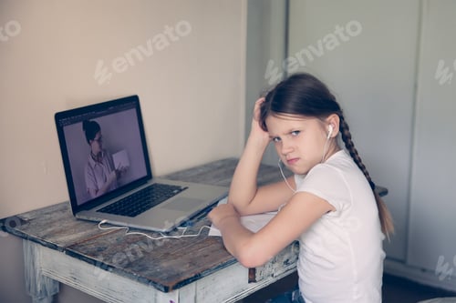 Preview: Tired schoolgirl in front of a laptop is engaged with a teacher, distance learning and a tutor.