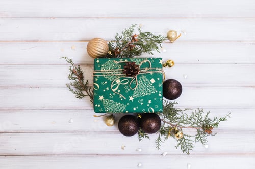 Preview: Wrapped Gift with Christmas Ornaments and Pine Branch