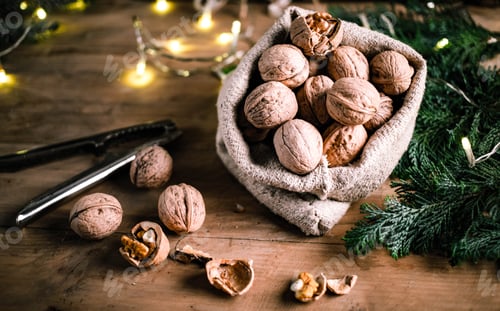 Preview: festive christmas nuts tumbling from a burlap bag
