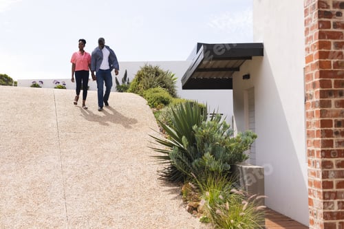Preview: Smiling Couple Strolling on Sunny Driveway