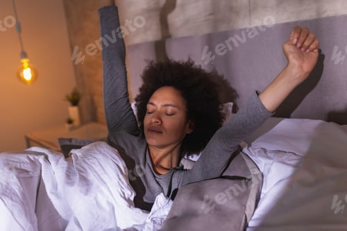 Preview: Woman stretching in bed after waking up